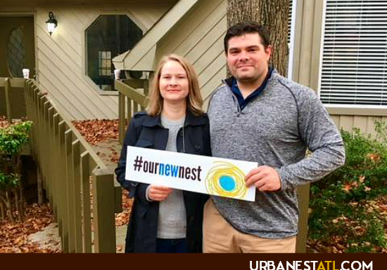 Atlanta home buyers holding a sign "Our New Urban Nest"